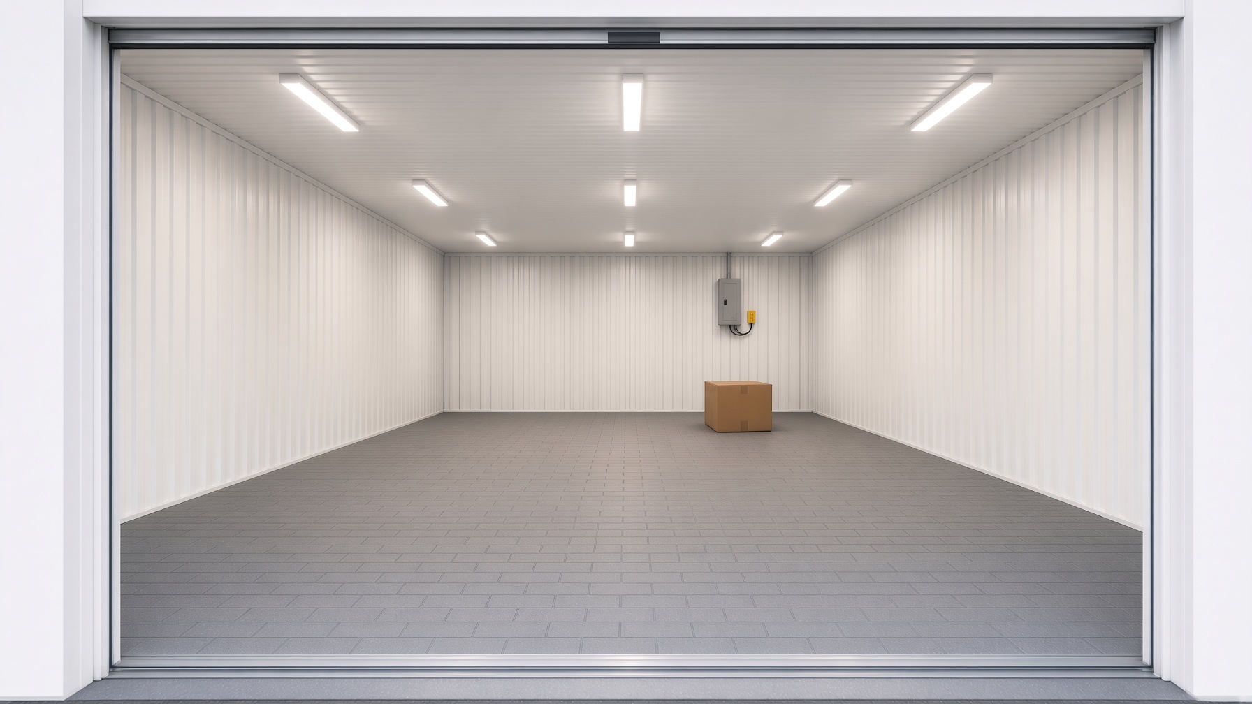 Empty warehouse bay with roller door open, white walls and a wide tiled floor